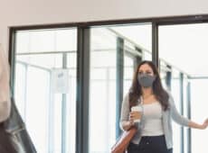 woman wearing protective mask while entering office building