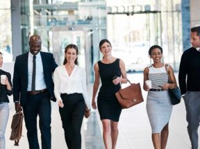 Shot of a group of confident businesspeople walking next to each other in a straight line at the office during the day