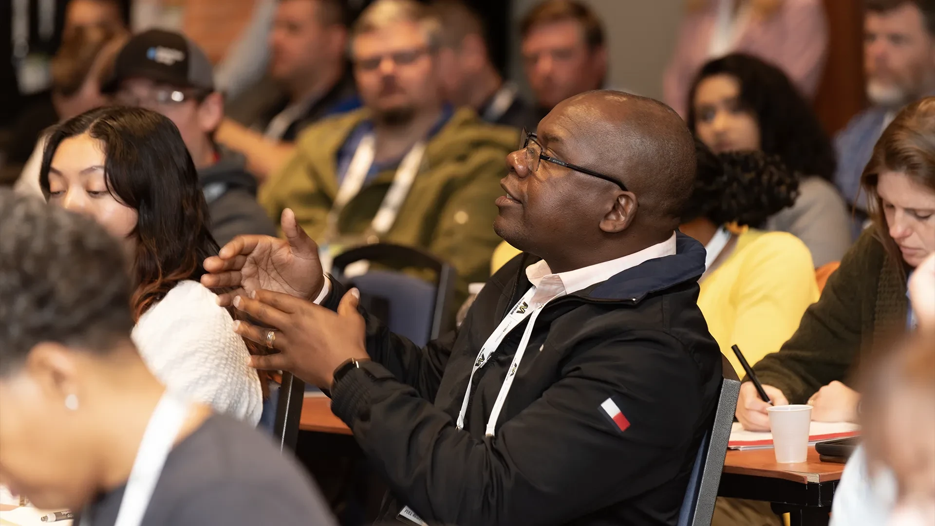 man in an audience asking a question of a presenter